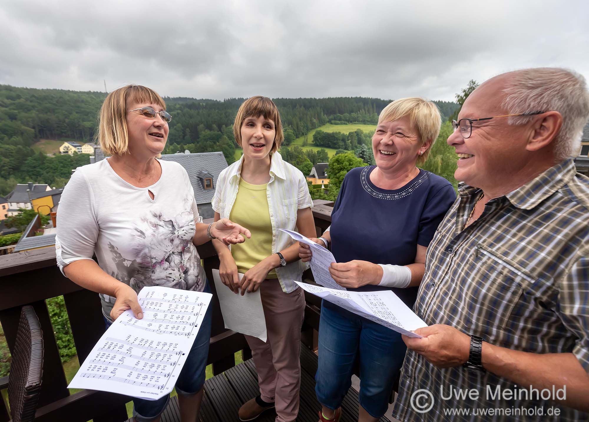 Wir, Heike, Birgit, Gabi und Winfried, haben Spaß am Singen Wir, Heike, Birgit, Gabi und Winfried, stehen mit Notenblättern in der Hand auf dem Balkon und haben Spaß am Singen